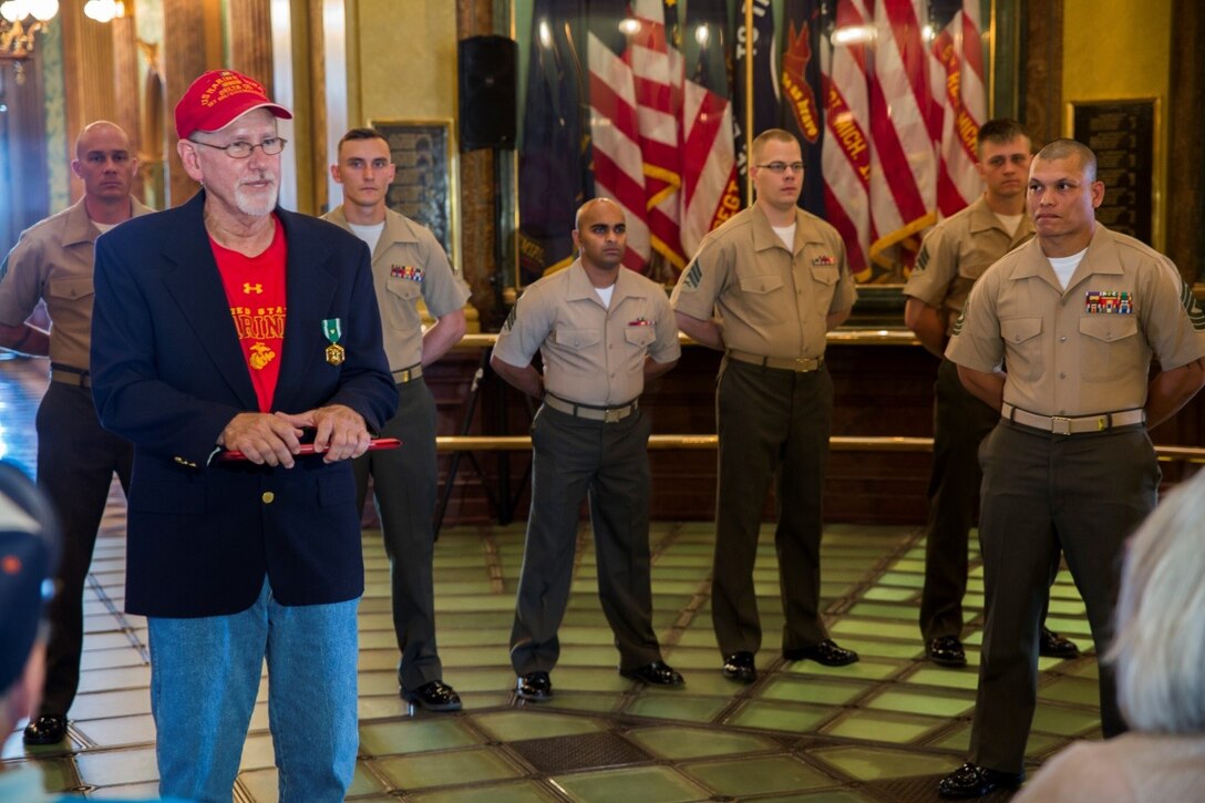 Marines with Company C, 1st Battalion, 24th Marines, 25th Marine Regiment, listen as Daniel S. Baldwin, a Marine veteran who served in Vietnam, addresses the crowd during the award ceremony where he was presented the Navy Commendation Medal with a bronze “V” for valor at the State Capitol building Sept. 2, 2016. Baldwin spoke about how proud he was to be a part of the Marine Corps and that he was honored to have Marines of past and present be a part of this memorable day. (U.S. Marine Corps photo by Cpl. Melissa Martens/ Released)  