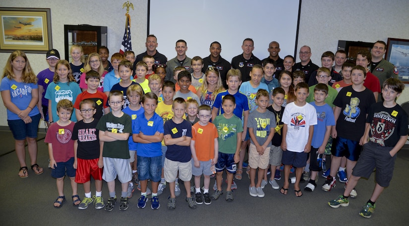 U.S. Air Force F-22 Raptor Demonstration Team poses with a group of students from Ypsilanti, Mich., at the Yankee Air Museum in Willow Run, Mich., Aug. 20, 2016.  The team met with the group to discuss the upcoming air show and what it takes to become a member of the demonstration team.  (U.S. Air Force photo by 2nd Lt. Mahalia Frost)