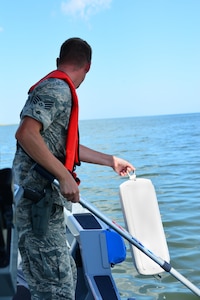 U.S. Air Force Staff Sgt. Shawn McNamara, 633rd Security Forces Squadron boat patrolman, demonstrates a man overboard drill during a routine patrol in the Back River, Va., Aug. 17, 2016. SFS must train and stay vigilant for any situation that may happen out on patrol. (U.S. Air Force photo by Airman 1st Class Tristan Biese)