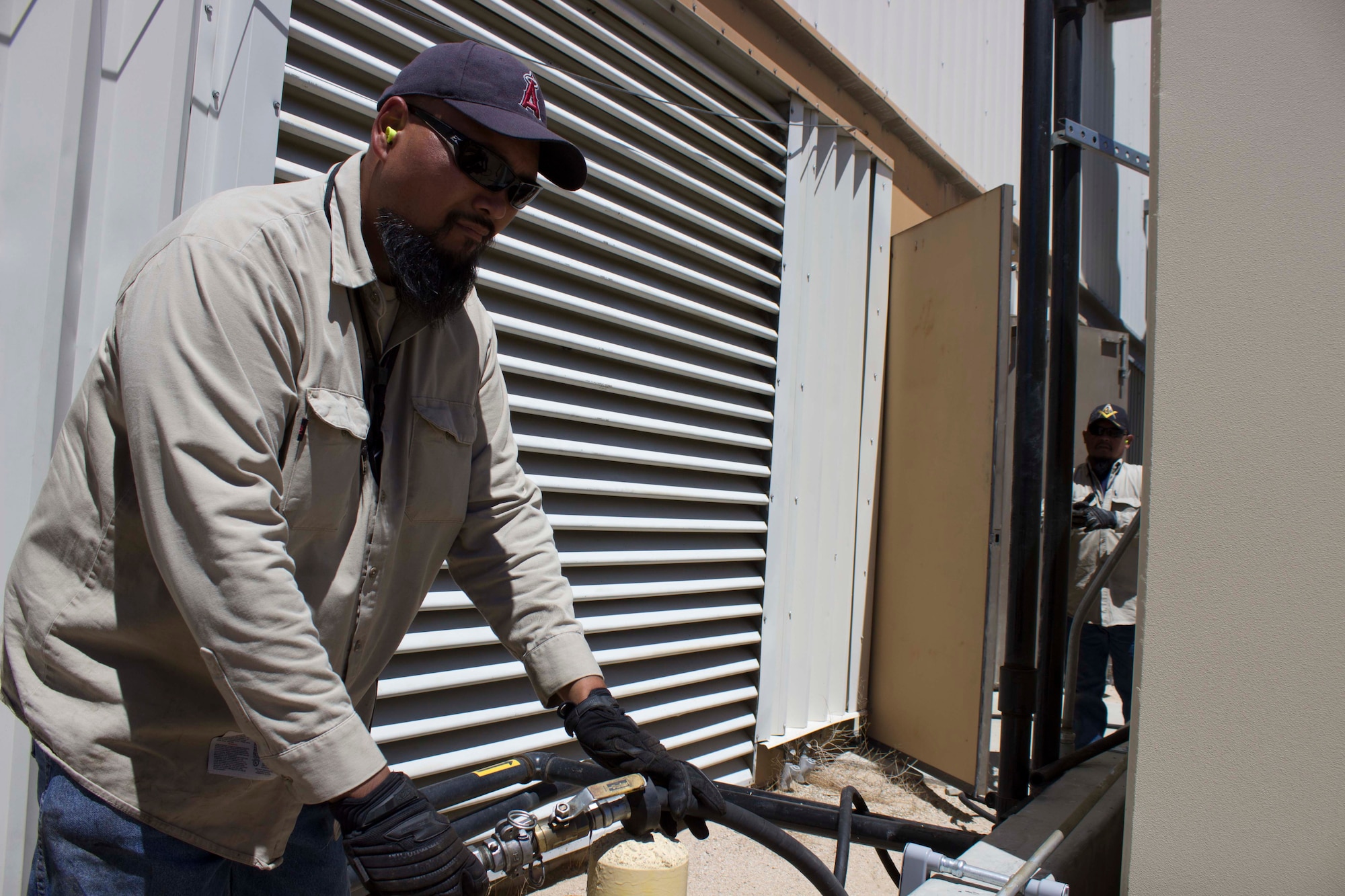 Jerry Davison assists CEMIRT by preparing the oil pump system to drain the oil from a 1000 kilowatt Caterpillar 3512 generator engine. Davison is one of six power production technicians at Edwards AFB, California. (U.S. Air Force Photo/Susan Lawson)