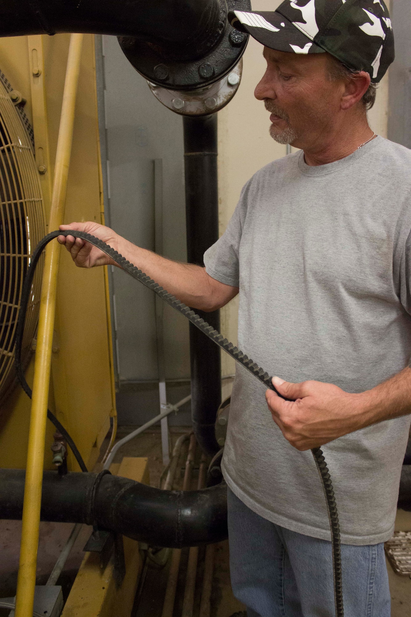 Mike Powers, powered support systems mechanic from CEMIRT, Travis, inspects a 1000 kilowatt Caterpillar 3512 generator fan belt that was discovered to have cracks. CEMIRT assists bases in performing preventive maintenance, saving the Air Force millions of dollars in repairs by conducting maintenance that base teams don’t have the manpower to support. (U.S. Air Force Photo/Susan Lawson)