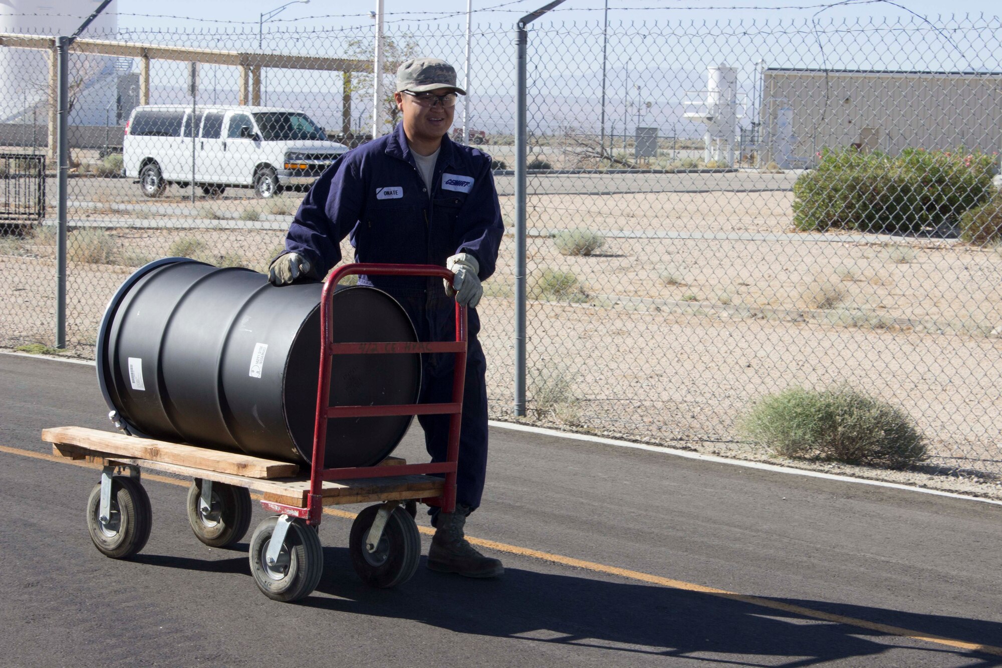 Tech. Sgt. Francis Onate wheels over a barrel to allow for the proper removal of oil from a 1000 kilowatt Caterpillar 3512 generator. All hazardous waste, such as used oil, requires proper handling, removal and disposal. (U.S. Air Force Photo/Susan Lawson)