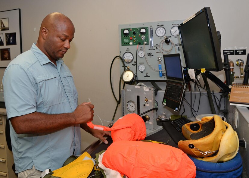 Harold R. Washington, 9th Physiological Support Squadron suit maintenance technician, inflates the life preserve device of a full pressure suit Aug. 31, 2016, at Beale Air Force Base, California. In the event of a crash the life preserve device is designed to inflate upon contact with water. (U.S. Air Force photo/Airman Tristan D. Viglianco)