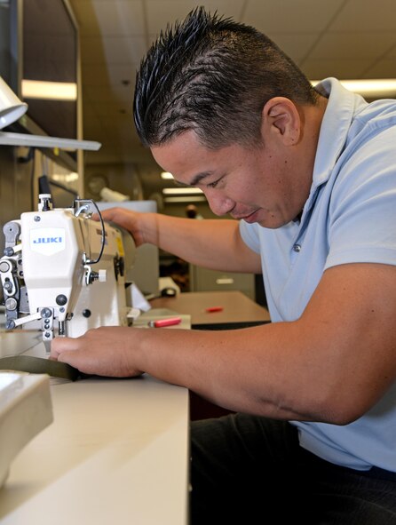 Reynato Ancheta, 9th Physiological Support Squadron full pressure suit technician, sows a hold down strap Aug. 31, 2016, at Beale Air Force Base, California. The hold down strap keeps the helmet in place when the suit expands, allowing the pilot to see clearly. (U.S. Air Force photo/Airman Tristan D. Viglianco)