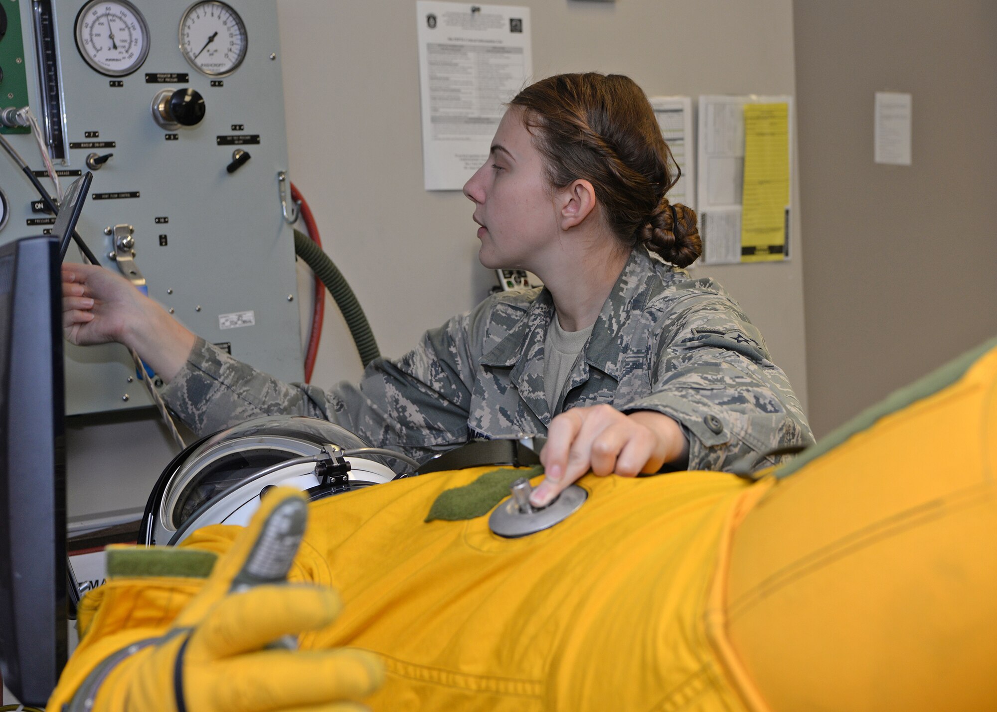 Airman 1st Class Heather Kennedy, 9th Physiological Support Squadron full pressure suit technician, inflates a full pressure suit to check if there are any leaks Aug. 31, 2016, at Beale Air Force Base, California.  The suit allows for the pilot to fly higher than Armstrong's line by maintaining pressure around the pilot. Armstrong's line is the altitude at which fluids begin to boil at human body temperature. (U.S. Air Force photo/Airman Tristan D. Viglianco)
