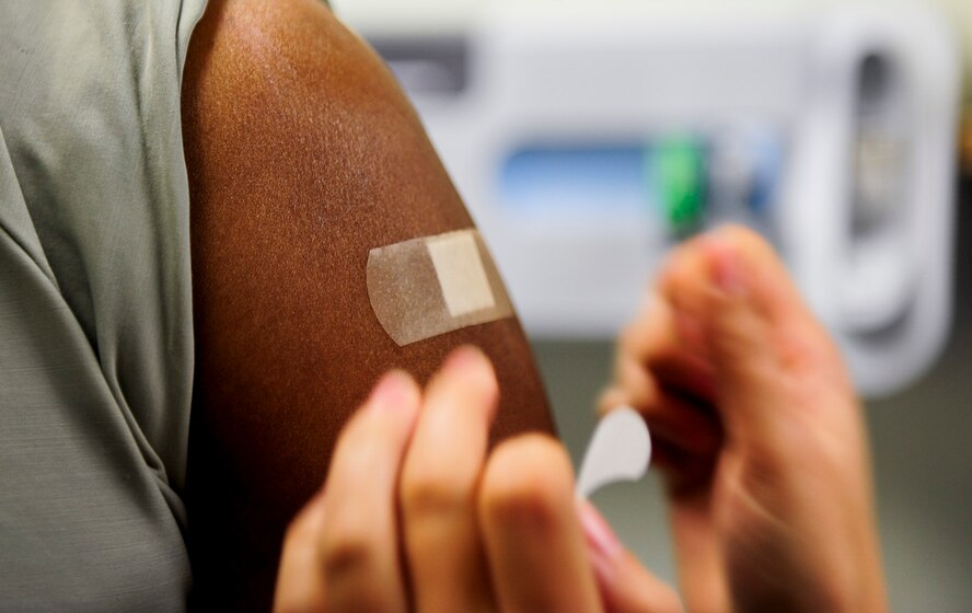 U.S. Air Force Chief Master Sgt. Bruce McKenzie, 8th Medical Group superintendent, receives a band aid after receiving a flu vaccination from Staff Sgt. Jessica Smith, immunizations non-commissioned officer in charge, at the 8th Medical Group facility, Kunsan Air Base, Republic of Korea, Sept. 7, 2016. Flu vaccinations are given every fall to ensure the health of the airmen and readiness of the Air Force. (U.S. Air Force photo/Senior Airman Colville McFee) 