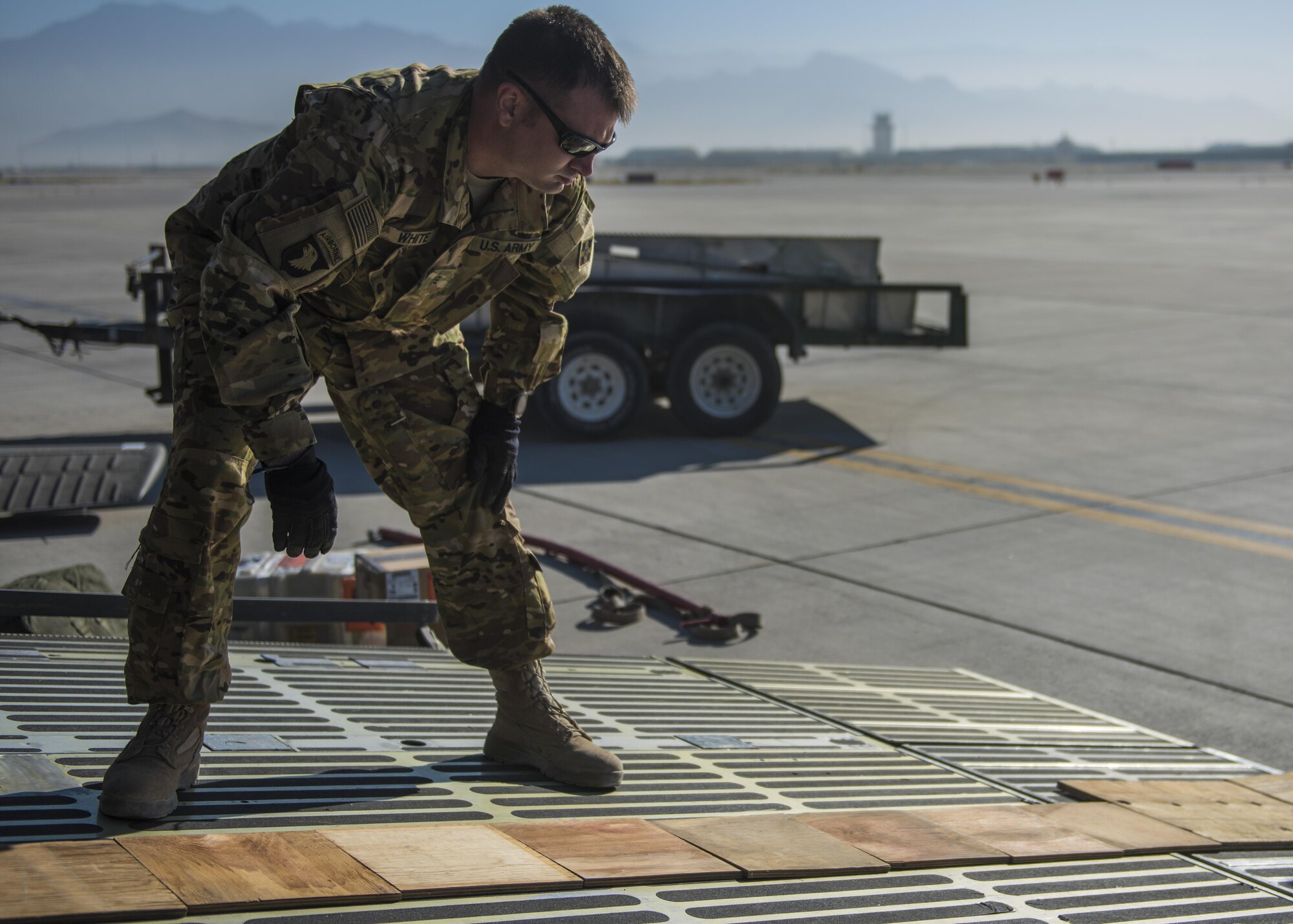 U.S. Army Chief Warrant Officer 3 Daniel White, brigade aviation maintenance officer, aligns wood pieces on a C-5 Galaxy, Bagram Airfield, Afghanistan, Sept. 8, 2016. The wood pieces were used to build a ramp to help load a Sikorsky UH-60 Blackhawk for transport. The Air Force C-5 Galaxy is a military transport aircraft and can handle a payload of up to 5 helicopters. (U.S. Air Force photo by Senior Airman Justyn M. Freeman)