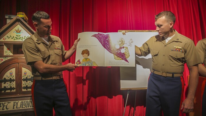 Capt. Cray Pack, left, and Capt. Nolan Utterback, right, read a story to children at the Nashville Public Library in Nashville, Tenn., Sept. 7, 2016. Pack is an AH-1W Cobra pilot and Utterback is a UH-1Y Venom pilot with Marine Light Attack Helicopter Squadron 167 based out of New River, N.C. Marine Week Nashville celebrates the contributions of local Marines whose service to our nation has protected and preserved our way of life for hundreds of years.