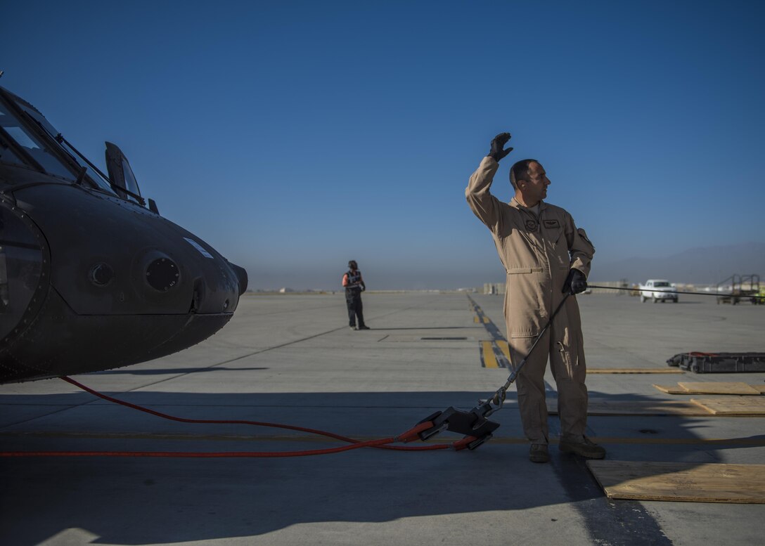 Tech. Sgt. John Crowe, 436th Airlift Wing aircraft loadmaster, connects a tow cable to a Sikorsky UH-60 Blackhawk, Bagram Airfield, Afghanistan, Sept. 8, 2016. An aircrew from Dover Air Force Base traveled to Bagram, to assist Army flying units pack and transport the Blackhawks back to home stations. (U.S. Air Force photo by Senior Airman Justyn M. Freeman)