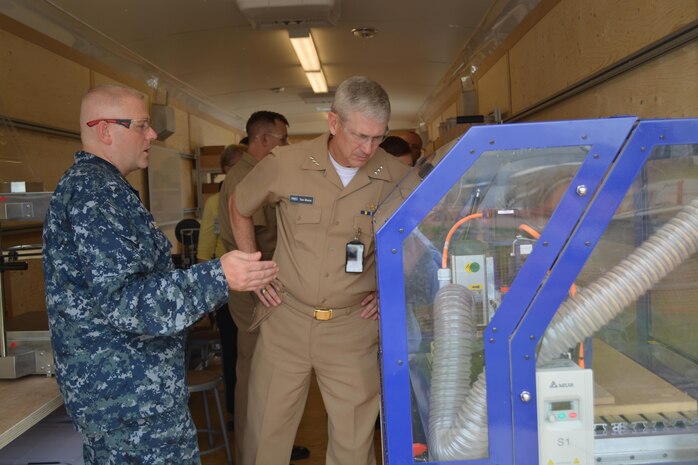 Senior Chief Machinery Repairman Sean A. Boykin explains the functionality of a 3-D Computer Numerically Controlled (CNC) Router to VADM Thomas J. Moore, Naval Sea Systems Commander inside the Fabrication Laboratory, or Fab Lab, at Southeast Regional Maintenance Center (SERMC).  