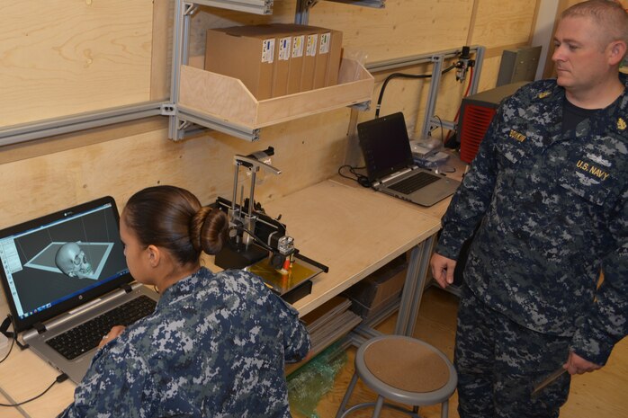 Machinery Repairman Senior Chief Shawn Boykin observes as Machinery Repairman 2nd Class Lisa Petyak as she experiments with the 3-D printing capabilities inside the new Fabrication Laboratory, or Fab Lab at SERMC. DARPA delivered the Fab Lab to SERMC earlier this month under their Manufacturing Experimentation and Outreach Two (MENTOR2) program. 