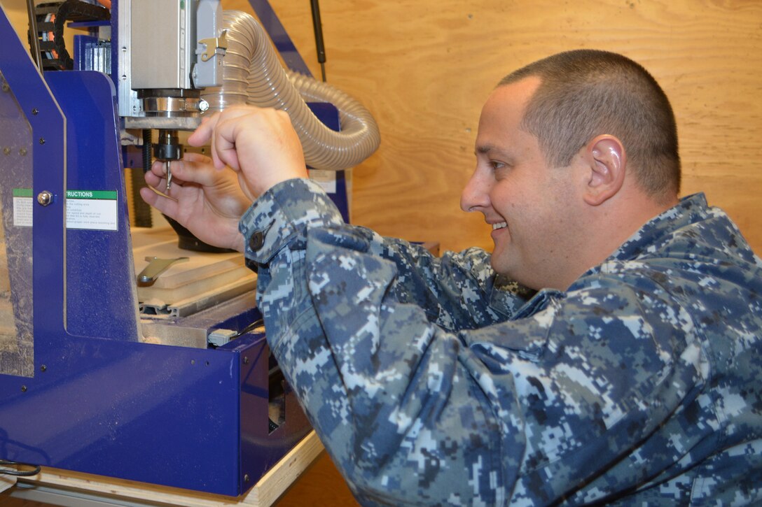 Machinery Repairman 1st Class Charles Baylis changes a router bit on a CNC Router inside SERMC's Fabrication Laboratory, or Fab Lab. Machinery Repairmen make replacement parts and repair or overhaul ship's engines and auxiliary systems. 