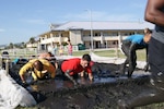 Runners race through obstacles during the Morale, Welfare and Recreation (MWR) Mayport Mud Run 2016. The event is an annual fitness challenge hosted by MWR for service members and their families to promote health and well-being.