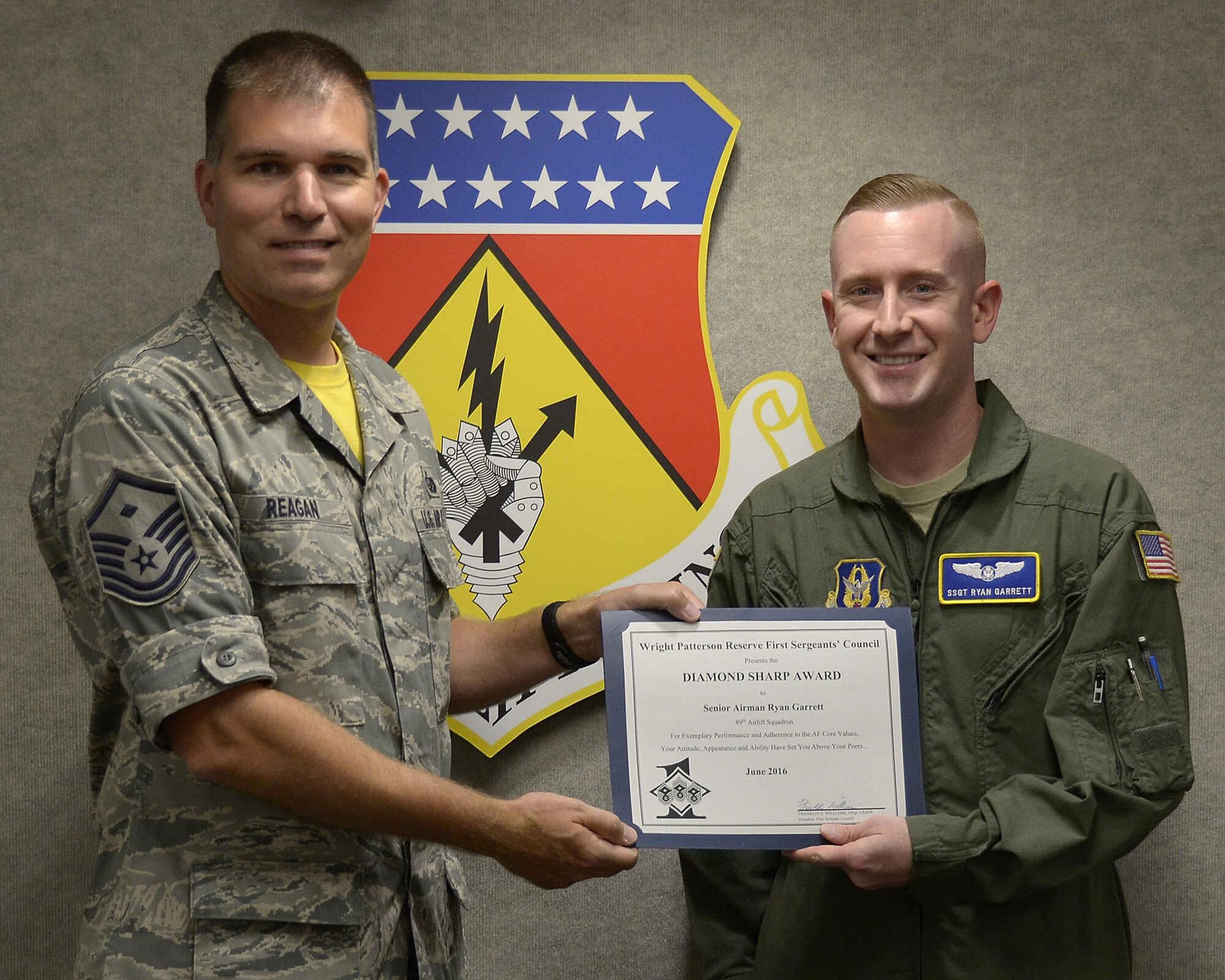 Master Sgt. David Reagan, 445th Aeromedical Evacuation Squadron first sergeant, presents the June 2016 Wright-Patterson Reserve First Sergeant's Council Diamond Sharp Award to Staff Sgt. Ryan Garrett, 89th Airlift Squadron C-17 pilot, August 6, 2016. The Diamond Sharp Award recognizes an Airman’s exemplary performance, adherence to the Air Force core values, attitude, appearance and ability to set himself above his peers. (U.S. Air Force photo/Staff Sgt. Joel McCullough)
