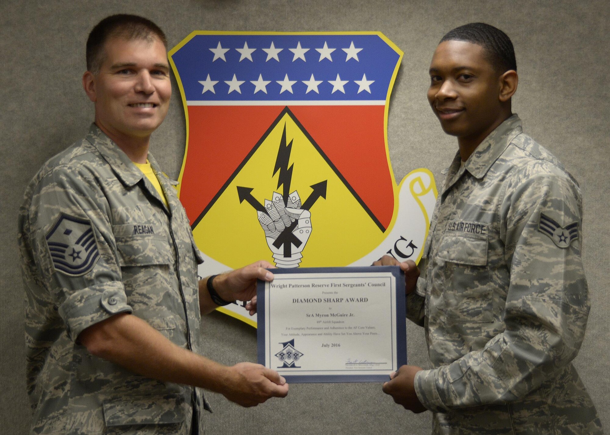Master Sgt. David Reagan, 445th Aeromedical Evacuation Squadron first sergeant, presents the June 2016 Wright-Patterson Reserve First Sergeant's Council Diamond Sharp Award to Senior Airman Myron McGuire, Jr., 89th Airlift Squadron, August 6, 2016. The Diamond Sharp Award recognizes an Airman’s exemplary performance, adherence to the Air Force core values, attitude, appearance and ability to set himself above his peers. (U.S. Air Force photo/Staff Sgt. Joel McCullough)