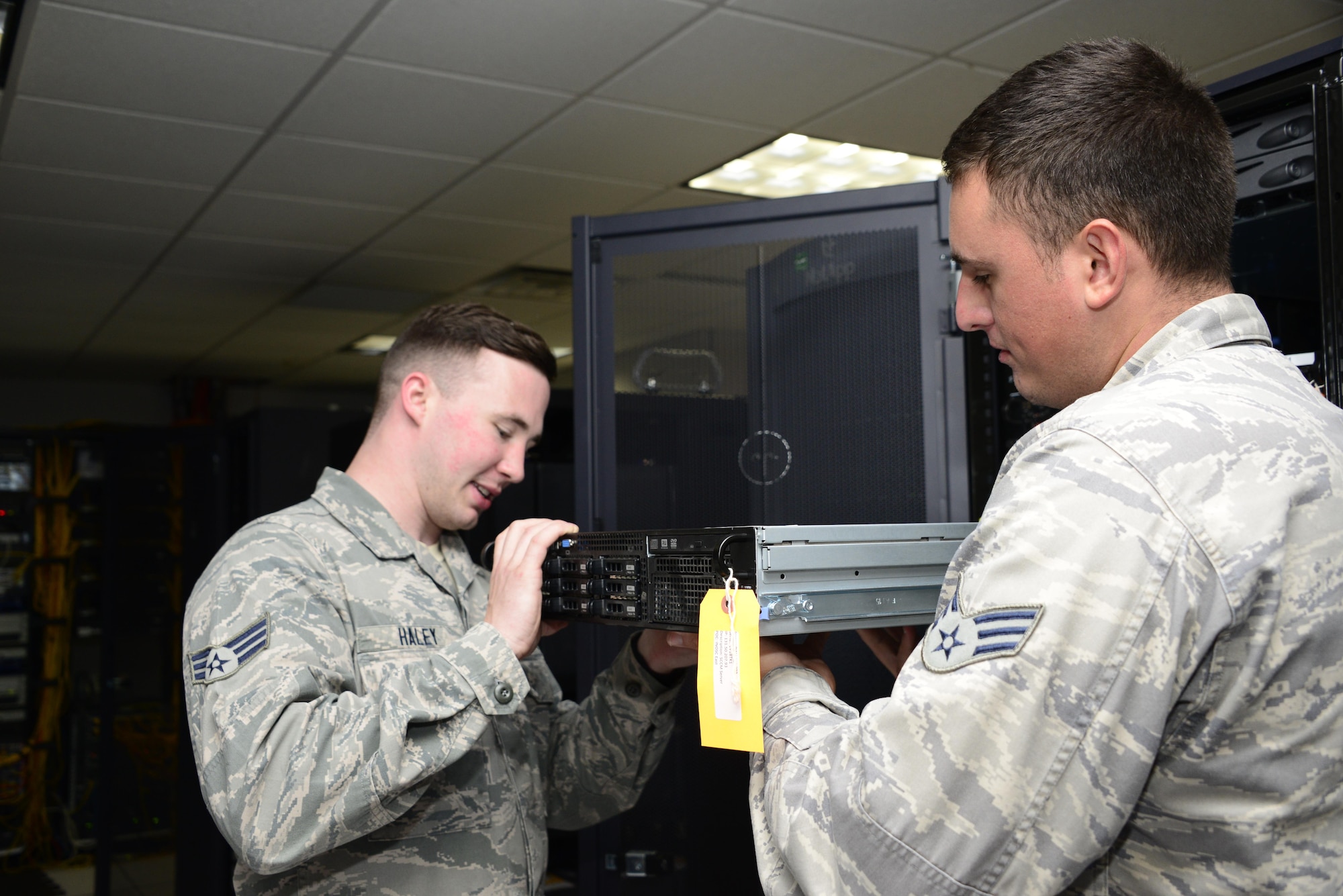 U.S. Air Force Senior Airmen Bradley Haley and Caige Kelly, 355th Communications Squadron network operations technicians, remove and replace a server at Davis-Monthan Air Force Base, Ariz., Sept. 7, 2016. The network operations team will be installing a scripting server which will be used to install software and security patches to the base network. (U.S. Air Force photo by Senior Airman Betty R. Chevalier)