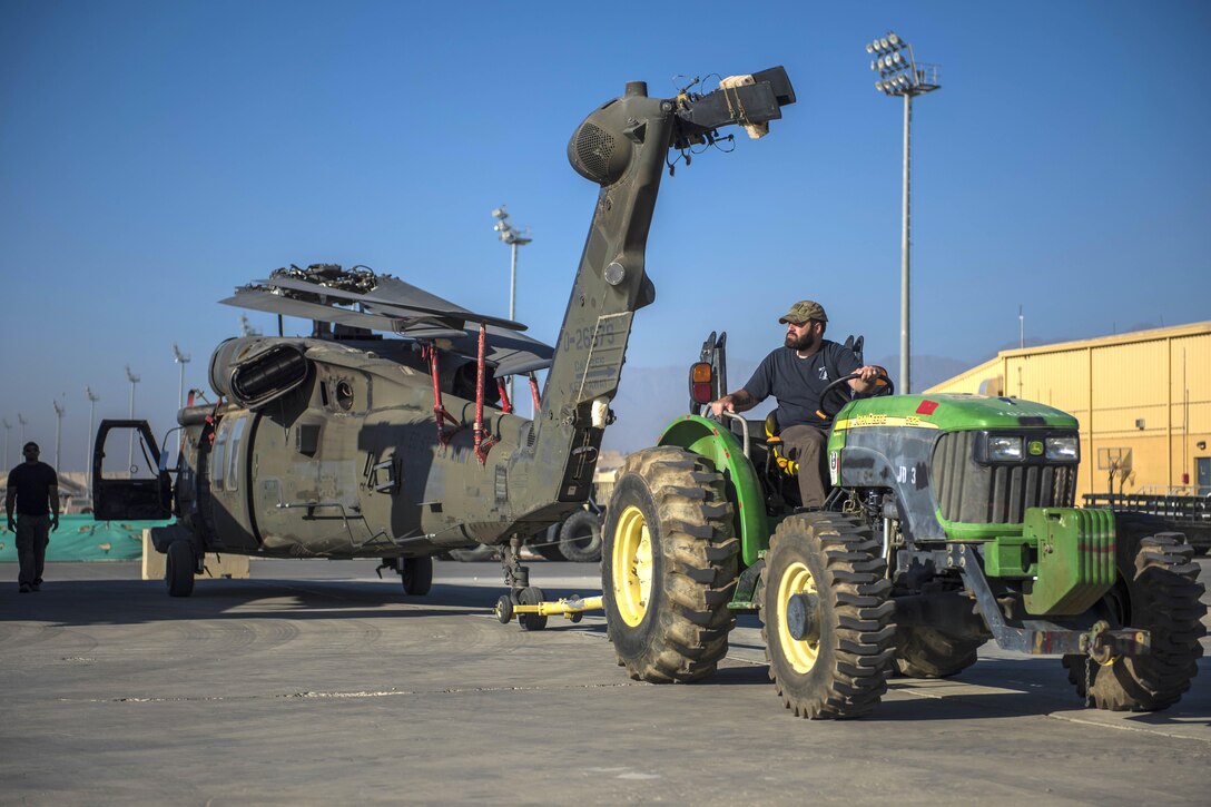 Anthony Fruge, Department of Defense contractor, uses a tractor to tow a UH-60 Black Hawk helicopter at Bagram Airfield, Afghanistan, Sept. 8, 2016. Air Force photo by Senior Airman Justyn M. Freeman