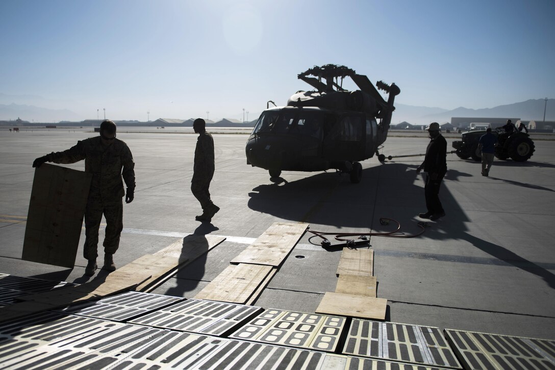Soldiers and airmen work with Department of Defense contractors to load an UH-60 Black Hawk helicopter onto a C-5 Galaxy aircraft at Bagram Airfield, Afghanistan, Sept. 8, 2016. Air Force photo by Senior Airman Justyn M. Freeman