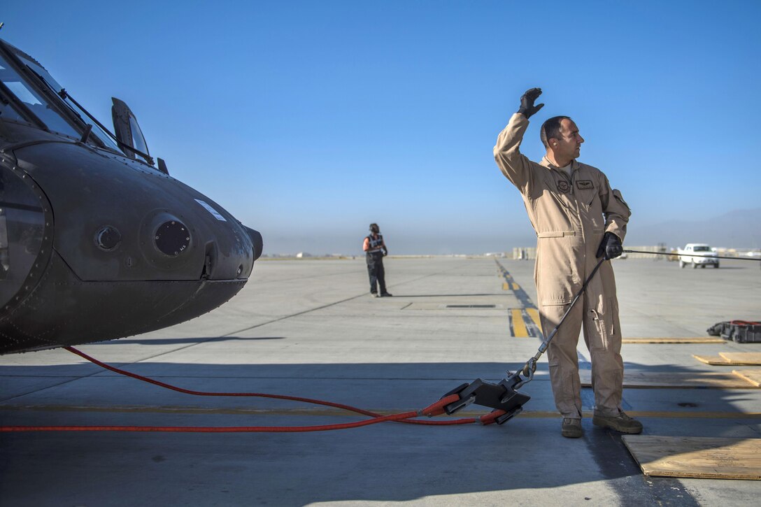 Air Force Tech. Sgt. John Crowe connects a tow cable to an UH-60 Black Hawk helicopter before its loaded into a C-5 Galaxy aircraft at Bagram Airfield, Afghanistan, Sept. 8, 2016. Crowe is an aircraft loadmaster assigned to the 436th Airlift Wing, deployed from Dover Air Force Base, Del. Air Force photo by Senior Airman Justyn M. Freeman