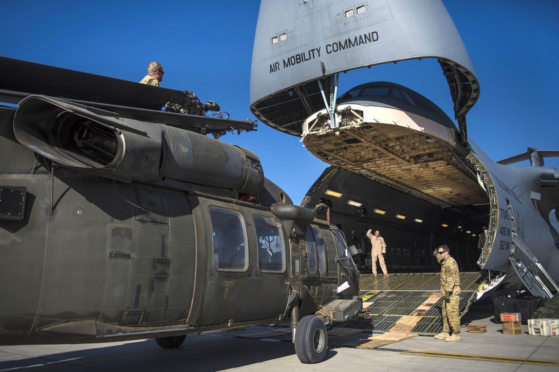 Soldiers and airmen load an UH-60 Black Hawk helicopter into a C-5 Galaxy aircraft at Bagram Airfield, Afghanistan, Sept. 8, 2016. Air Force photo by Senior Airman Justyn M. Freeman