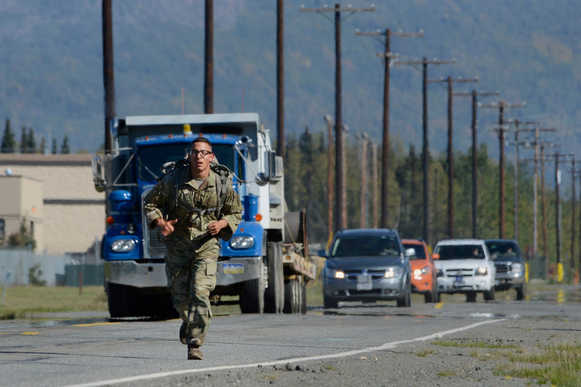 Spc. Joshua Padilla, assigned to the 1st Battalion, 501st Parachute Infantry Regiment, 4th Infantry Brigade Combat Team (Airborne), 25th Infantry Division, U.S. Army Alaska, competes in the Combat Cross-Country Series 10-Mile Relay on the Davis Highway, Sept. 1, 2016. The relay consisted of five-man teams in Army Combat Uniforms and combat boots racing for the best time with 35-pound rucksacks. 