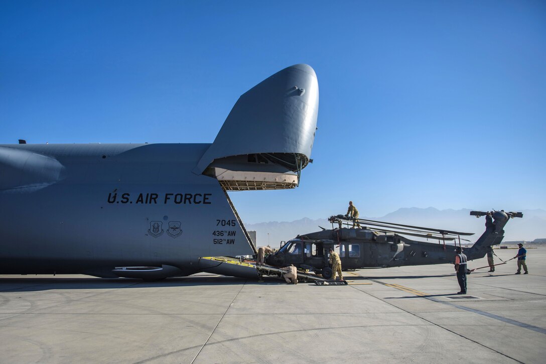 Soldiers and airmen prepare to load an UH-60 Black Hawk helicopter into a C-5 Galaxy aircraft at Bagram Airfield, Afghanistan, Sept. 8, 2016. Air Force photo by Senior Airman Justyn M. Freeman