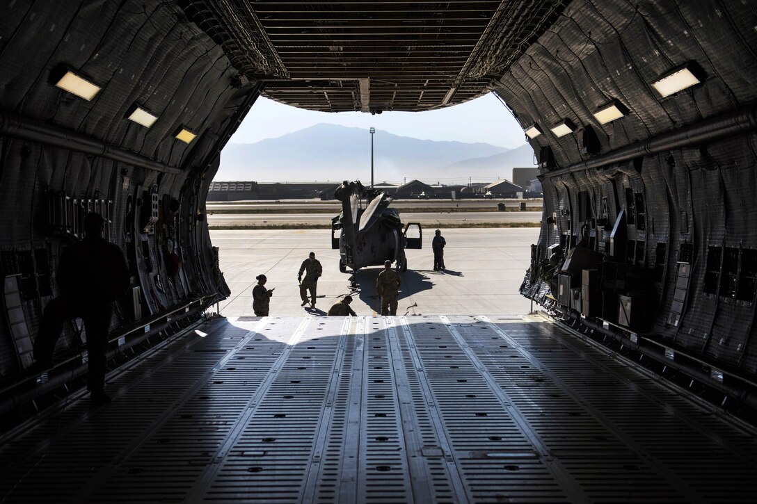 Soldiers and airmen guide an UH-60 Black Hawk helicopter before loading it into a C-5 Galaxy aircraft at Bagram Airfield, Afghanistan, Sept. 8, 2016. Air Force photo by Senior Airman Justyn M. Freeman
