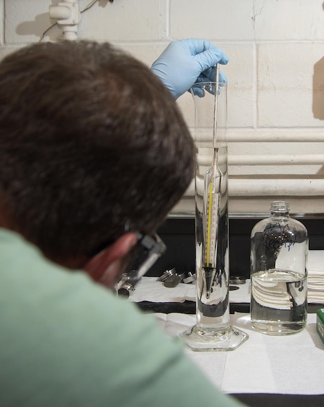 Jeff Goins, 88th Logistics Readiness Squadron fuel information service center lab technician, uses a hydrometer to check the specific gravity of a fuel sample Aug. 24, 2016, at Wright-Patterson Air Force Base, Ohio. Samples go through a battery of tests to protect against impurities and to ensure the proper level of anti-icing capabilities. (U.S. Air Force photo / R.J. Oriez)
