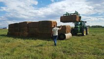 Staff Sgt. Daniel Jones, 341st Munitions Squadron, guides a tractor Sept. 6, 2016, at Judith Basin, Montana. Airmen from the 341st Maintenance Group participated in “What the Hay,” a local event where teams build structures out of bales of hay. (Courtesy photo)