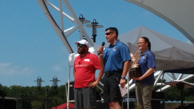 The 42nd Air Base Wing Commander Col. Eric Shafa and Command Chief, Chief Master Sgt. Laura Callaway present the Military Trophy to Air University's Air War College team for the fastest time in a 300-meter dragonboat race on Aug. 27, 2016. The 21-person team was one of four military teams that participated in the Montgomery Dragonboat Festival, which took place in downtown Montgomery's Riverwalk. The other three military teams included the 42nd Air Base Wing, Squadron Officer College, and Air Command and Staff College. (U.S. Air Force photo/ Lt. Col. Mae-Li Allison)
