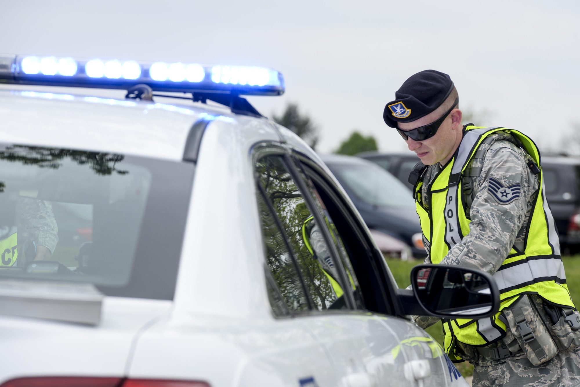 U.S. Air Force Staff Sgt. James Glass, 88th Security Forces Squadron patrolman, consults a map on the hood of his patrol car during a base exercise, May 3, 2016 at Wright-Patterson Air Force Base, Ohio. WPAFB holds exercises several times a year to ensure the base population is ready for a variety of scenarios that could occur. (U.S. Air Force photo / Wesley Farnsworth)