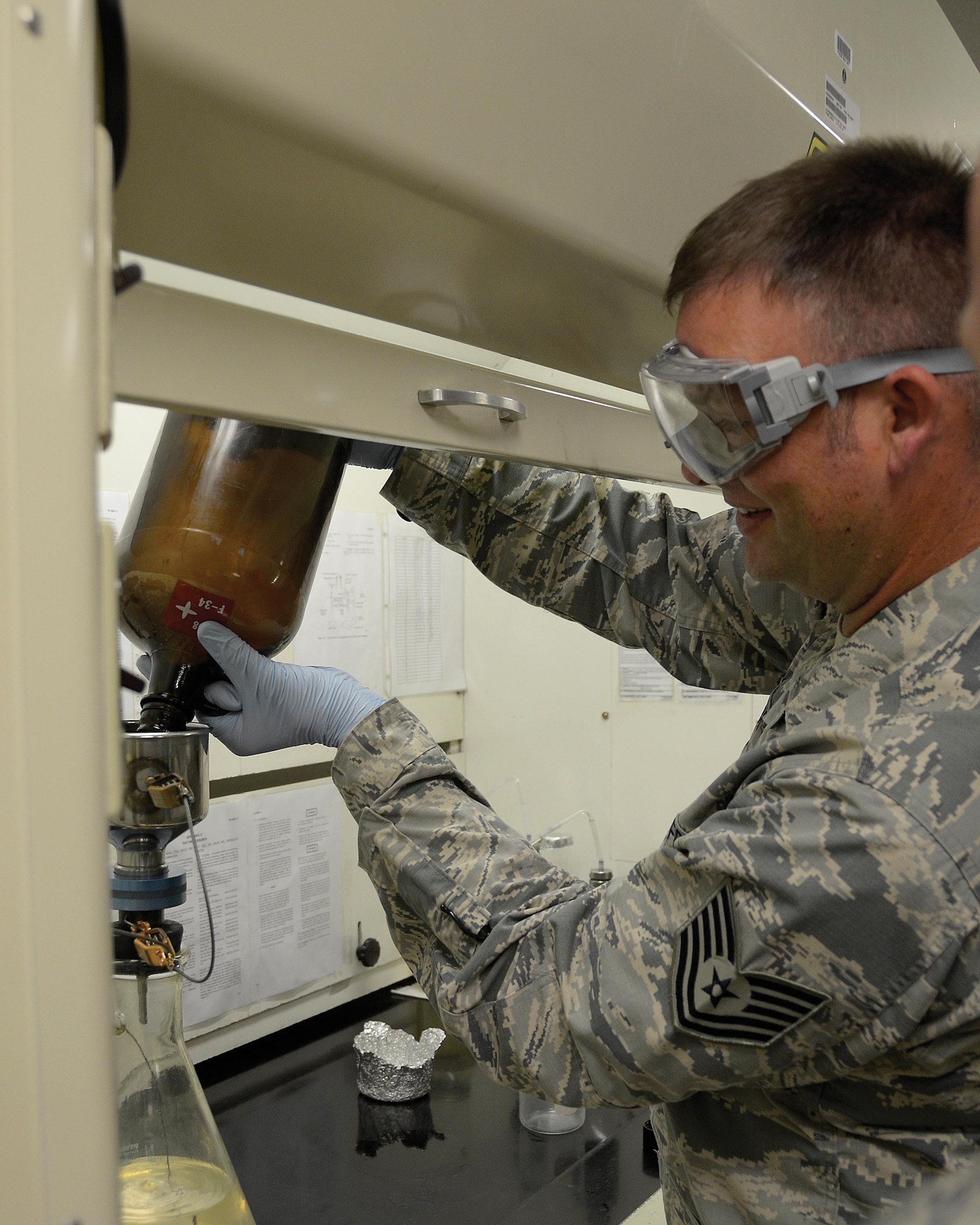 Tech. Sgt. Richard L. Blake, training manager of fuels flight for the 445th Logistics Readiness Squadron from Wright-Patterson Air Force Base, Ohio pours fuel while completing a bottle method test July 25, 2016. Blake worked alongside the 673rd LRS at their facility located on JBER for annual training. (U.S. Air Force photo/Staff Sgt. Joel McCullough)
