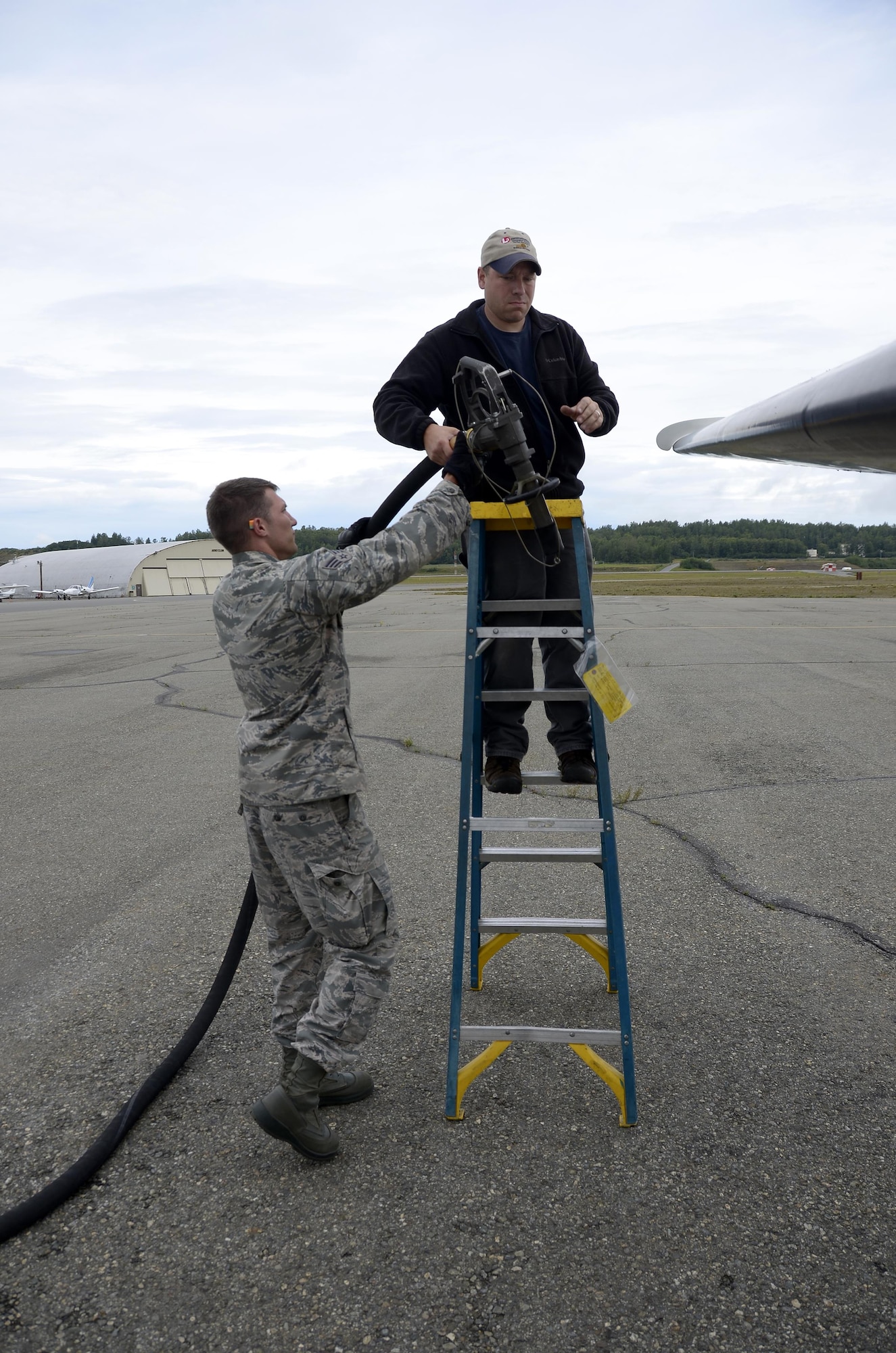 Senior Airman David K. Fink, a fuels specialist with the 445th Logistics Readiness Squadron from Wright-Patterson Air Force Base, Ohio assists a civilian maintenance personnel here as they fuel a C-12 Huron aircraft July 26, 2016 at JBER. The 445th Airman fueled many different aircraft platforms not seen at home station while on annual training. (U.S. Air Force photo/Staff Sgt. Joel McCullough)