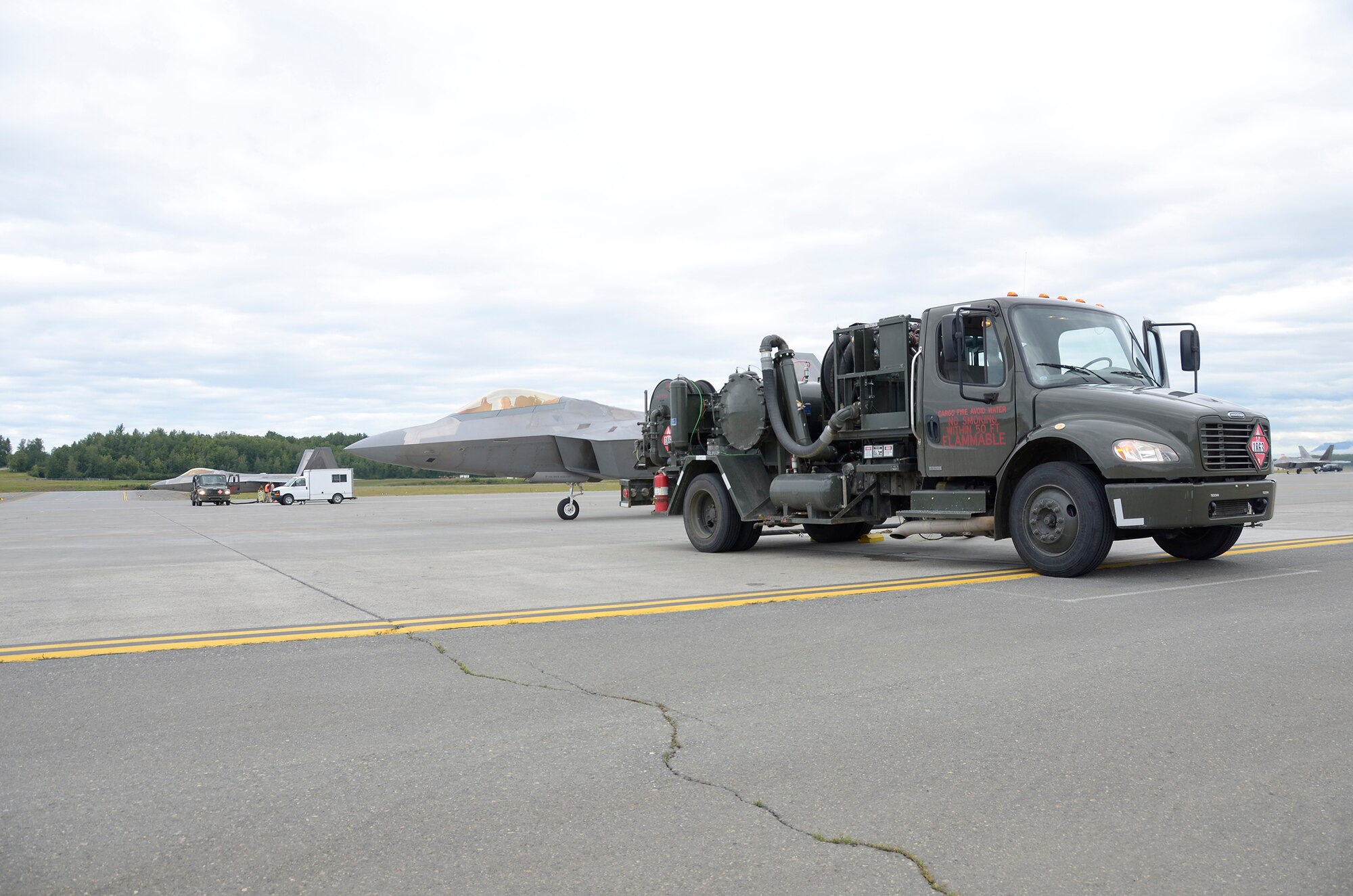 A fuel truck from the 673rd Logistics Readiness Squadron here sits in front of an F-22 Raptor July 27, 2016, at JBER. The 445th LRS from Wright-Patterson Air Force Base, Ohio attended annual training at JBER and were able to get hands on training with the F-22s. (U.S. Air Force photo/Staff Sgt. Joel McCullough)