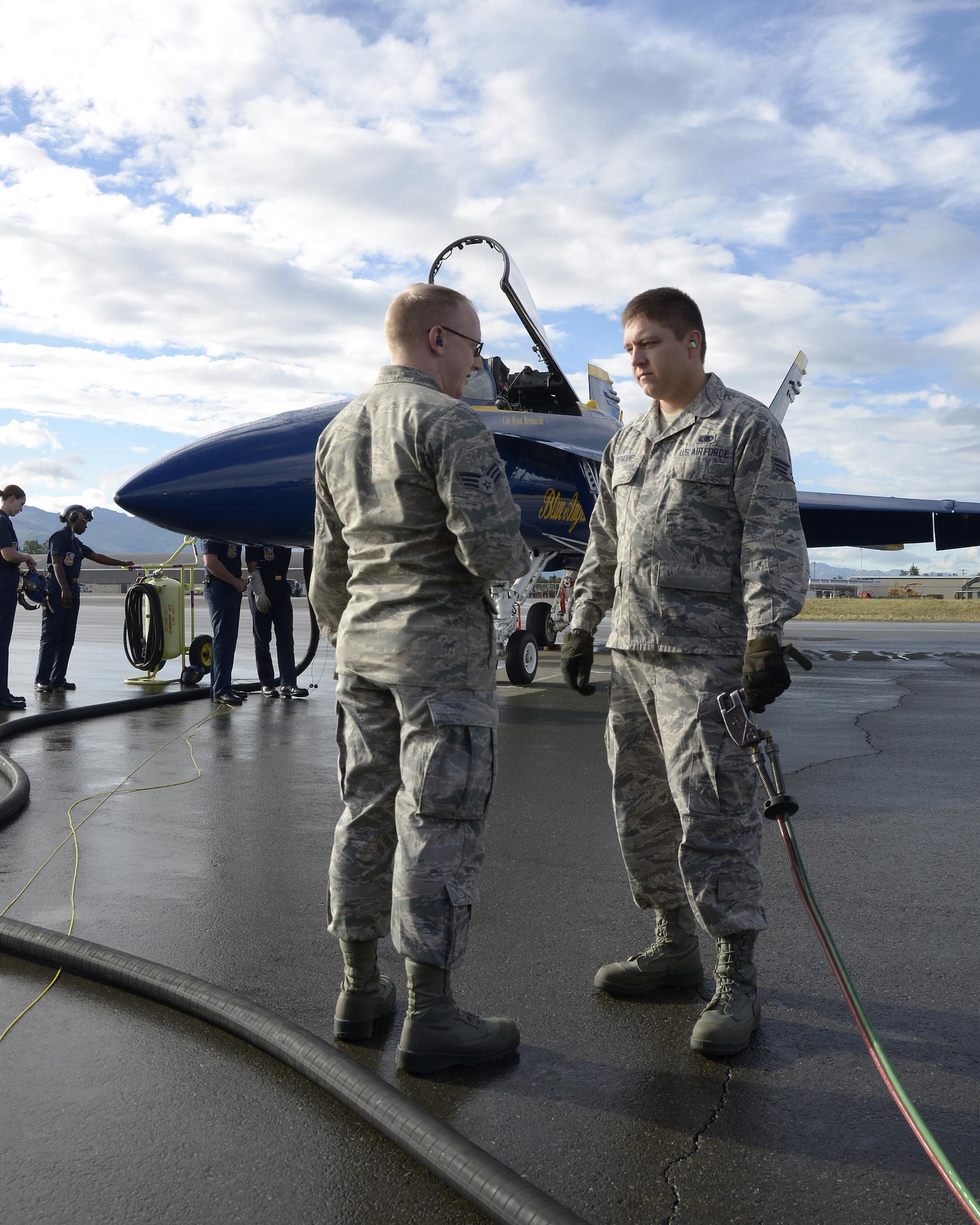 Senior Airmen Leo K. Reid and Darren M. Trenkamp, both fuels specialist from the 445th Logistics Readiness Squadron from Wright-Patterson Air Force Base, Ohio discuss procedures while refueling a Blue Angel F/A-18 Hornet here July 28, 2016. The Airmen worked alongside the Blue Angels crew to ensure the Hornets were fueled in preparation for the Artic Thunder air show being held at JBER. (U.S. Air Force photo/Staff Sgt. Joel McCullough)