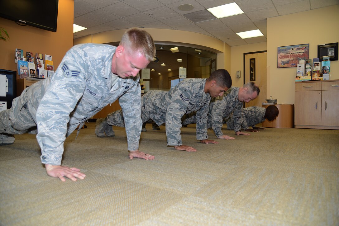 Senior Airman David Corley and Airman 1st Class Andres Simmons of the 812th Civil Engineer Squadron join Maj. Kevin Hooker and Airman 1st Class Gabriel Osirus of the 412th Medical Operations Squadron in their first set for the 22-Push-Up Challenge (U.S. Air Force photo by Christopher Ball)
