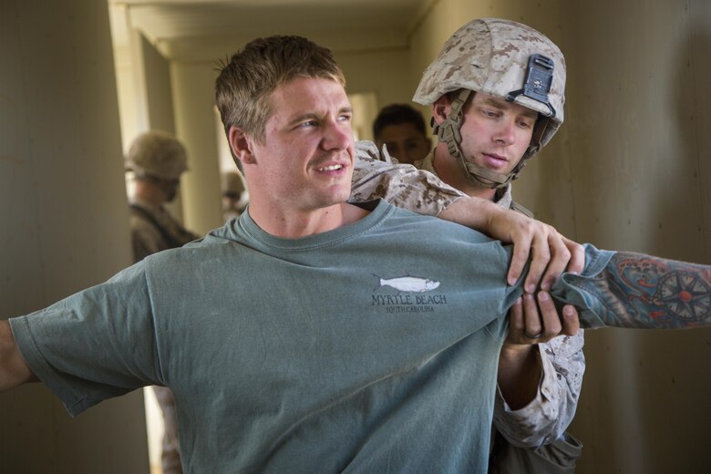 A Marine with Special Purpose Marine Air Ground Task Force, Crisis Response, Central Command, checks a role-player during a non-combatant evacuation operation exercise at Range 220, a military operations on urbanized terrain facility, aboard the Marine Corps Air Ground Combat Center, Twentynine Palms, Calif., Aug. 24, 2016. (Official Marine Corps photo by Lance Cpl. Levi Schultz/Released)