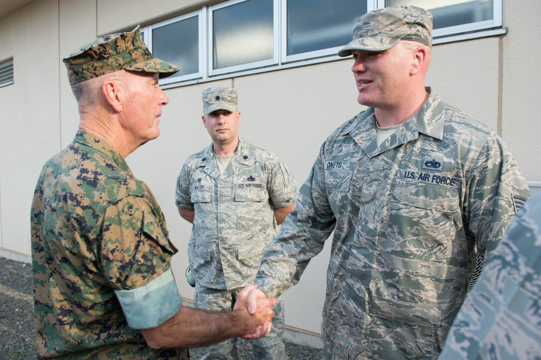 Marine Corps Gen. Joe Dunford, chairman of the Joint Chiefs of Staff, recognizes Air Force Tech Sgt. Garrett Oneto, support section noncommissioned officer in charge of the 374th Aircraft Maintenance Squadron at Yokota Air Base, Japan, for helping a fellow airman who was struggling and contemplating suicide, Sept. 7, 2016. DoD photo by Army Sgt. James K. McCann