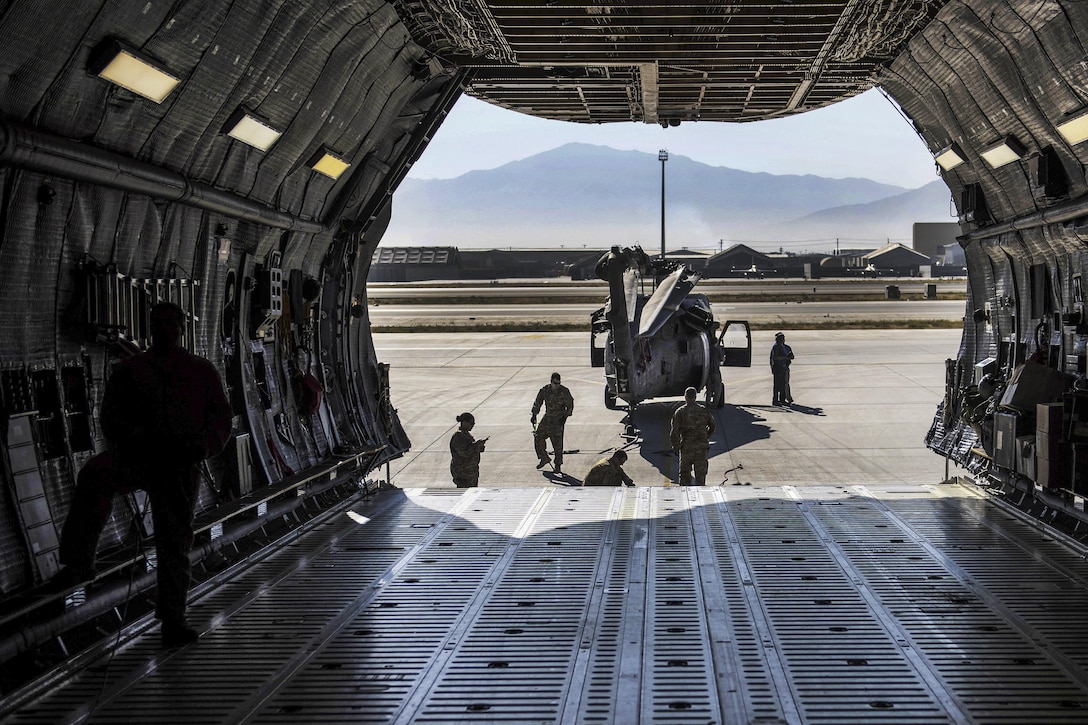Soldiers and airmen guide an UH-60 Black Hawk helicopter before loading it into a C-5 Galaxy aircraft at Bagram Airfield, Afghanistan, Sept. 8, 2016. Air Force photo by Senior Airman Justyn M. Freeman