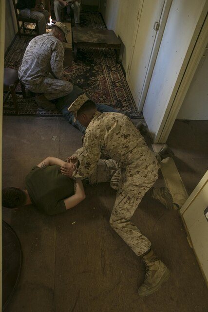 Lance Cpl. Adrian Lopez and Cpl. Bradley Antkowiak, military police officers, Provost Marshal’s Office, neutralize and handcuff notional enemies during a domestic disturbance simulation at Range 800 aboard the Marine Corps Air Ground Combat Center, Twentynine Palms, Calif., Aug. 30, 2016. PMO uses these drills to prepare for scenarios they could potentially encounter while out on patrol. (Official Marine Corps photo by Lance Cpl. Dave Flores/Released)