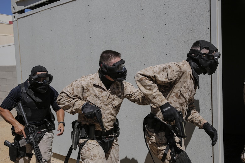 Civilians and Marines police officers from the Provost Marshal’s Office, enter a building during an active shooter exercise at Range 800 aboard Marine Corps Air Ground Combat Center, Twentynine Palms, Calif., Aug. 30, 2016. PMO uses these drills to prepare for scenarios they could potentially encounter while out on patrol. (Official Marine Corps photo by Lance Cpl. Dave Flores/Released)