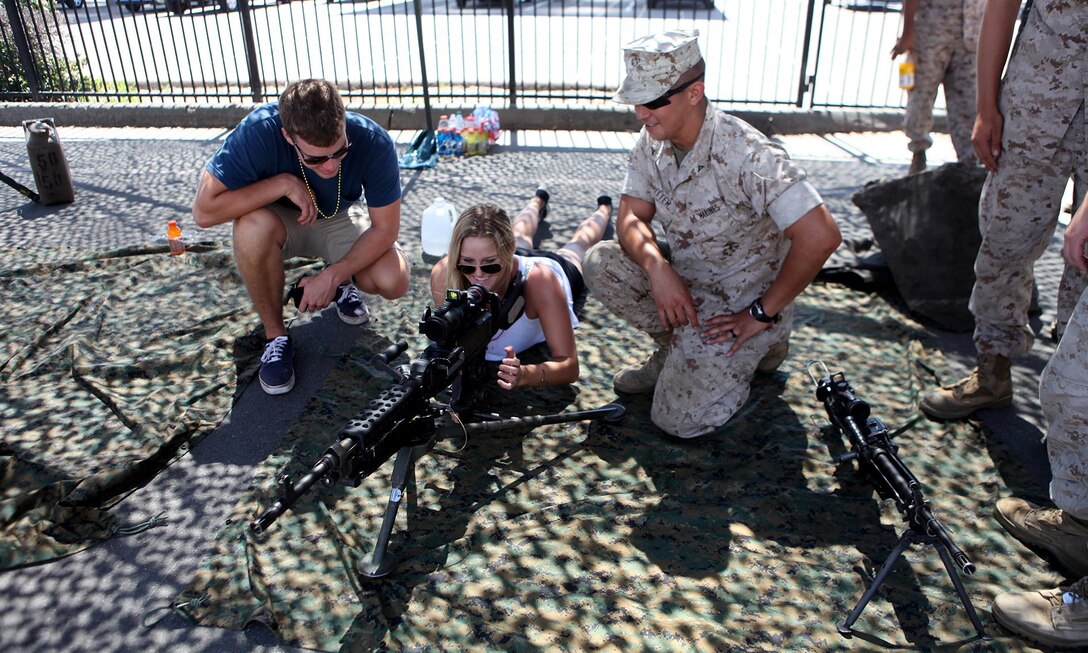 Lance Cpl. Matthew Ritter, a heavy equipment operator with Bulk Fuel Company, 7th Engineer Support Battalion, shows a couple a weapons system during San Diego Fleet Week 2015 aboard Naval Base Coronado, Calif., Sept. 20, 2015. Thirty-seven Marines from 7th ESB presented static displays during the event to demonstrate the quality of military assets to the citizens of San Diego. (U.S. Marine Corps photo by Sgt. Laura Gauna/released)