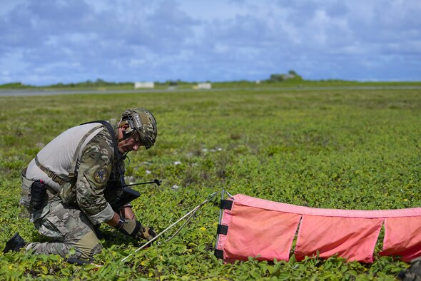 A 320th Special Tactics Squadron member sets up panels on the Wake Island runway so a MC-130J Commando II could land during an airfield seizure exercise Aug. 24, 2016. Members of the 320th STS and the III Marine Expeditionary Force, 31st Marine Expeditionary Unit, Force Reconnaissance Platoon conducted joint training to build interoperability between the two units. (U.S. Air Force photo/Senior Airmen Stephen G. Eigel)