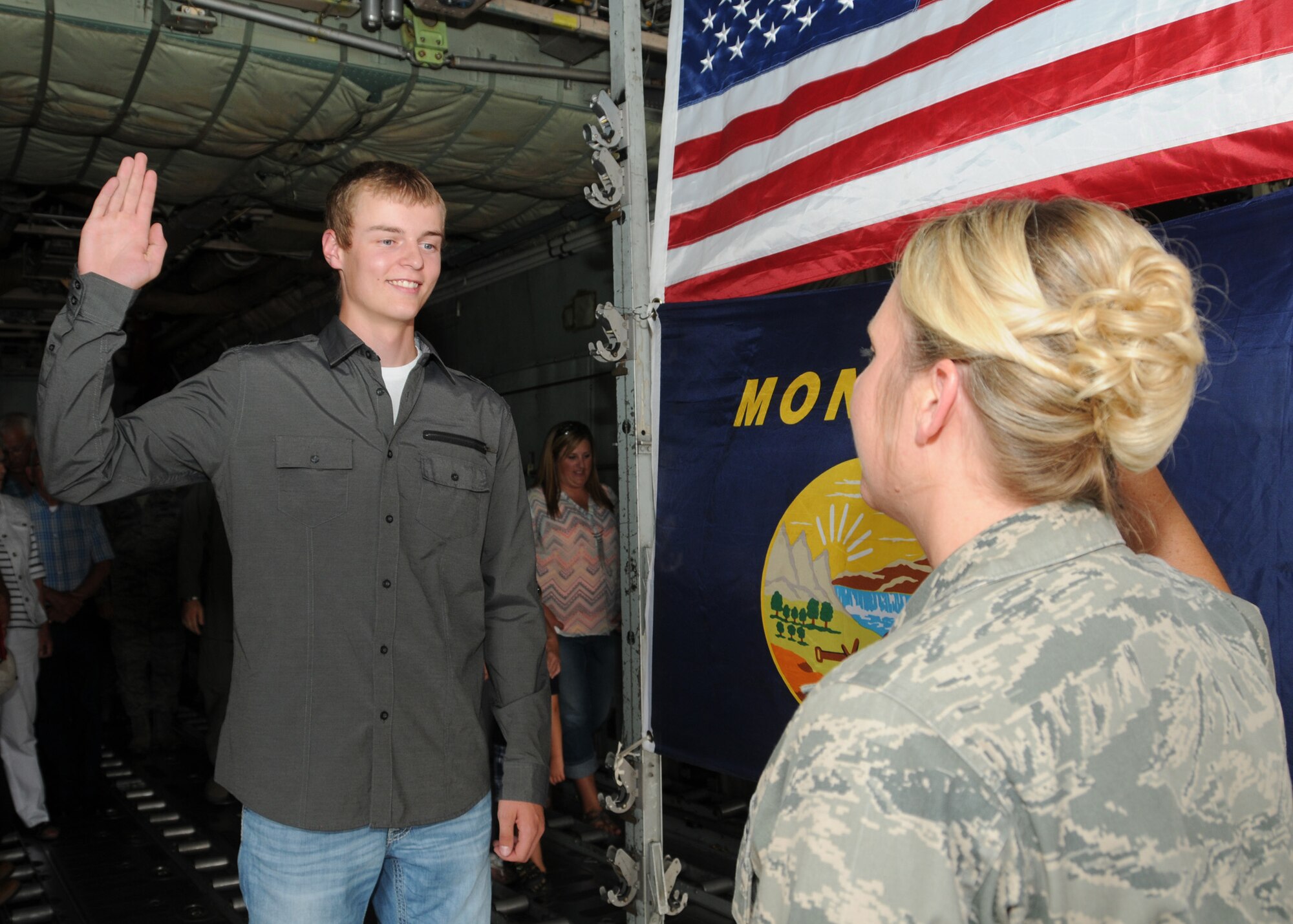 Tyler LaPierre recites the oath of enlistment during his Montana Air National Guard enlistment ceremony in the cargo hold of a C-130 Hercules transport aircraft parked at the 120th Airlift Wing in Great Falls, Mont. Aug. 31, 2016. His aunt, Capt. Jennifer LaPierre Gunter administered the oath. (U.S. Air National Guard photo by Senior Master Sgt. Eric Peterson)