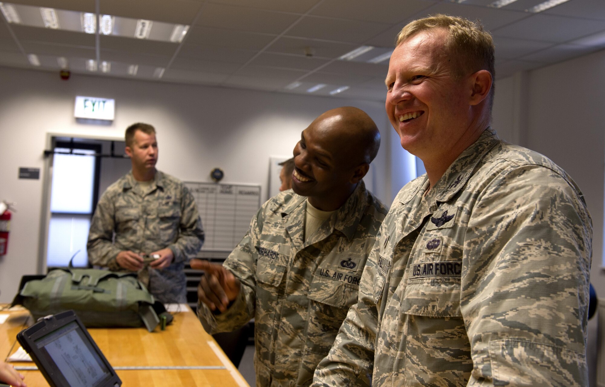 U.S. Air Force Col. Joseph McFall, 52nd Fighter Wing commander, right, and Tech. Sgt. Edward Eberhardt, 52nd Operations Support Squadron aircrew flight equipment flight chief, center, laugh during a Saber leadership “out and about” event at the parachute shop on Spangdahlem Air Base, Germany, Sept. 8, 2016. The event lets the 52nd FW commander and command chief get a hands on experience at Saber work centers in an effort to better understand the duties of Airmen at Spangdahlem. (U.S. Air Force photo by Airman 1st Class Preston Cherry/Released)