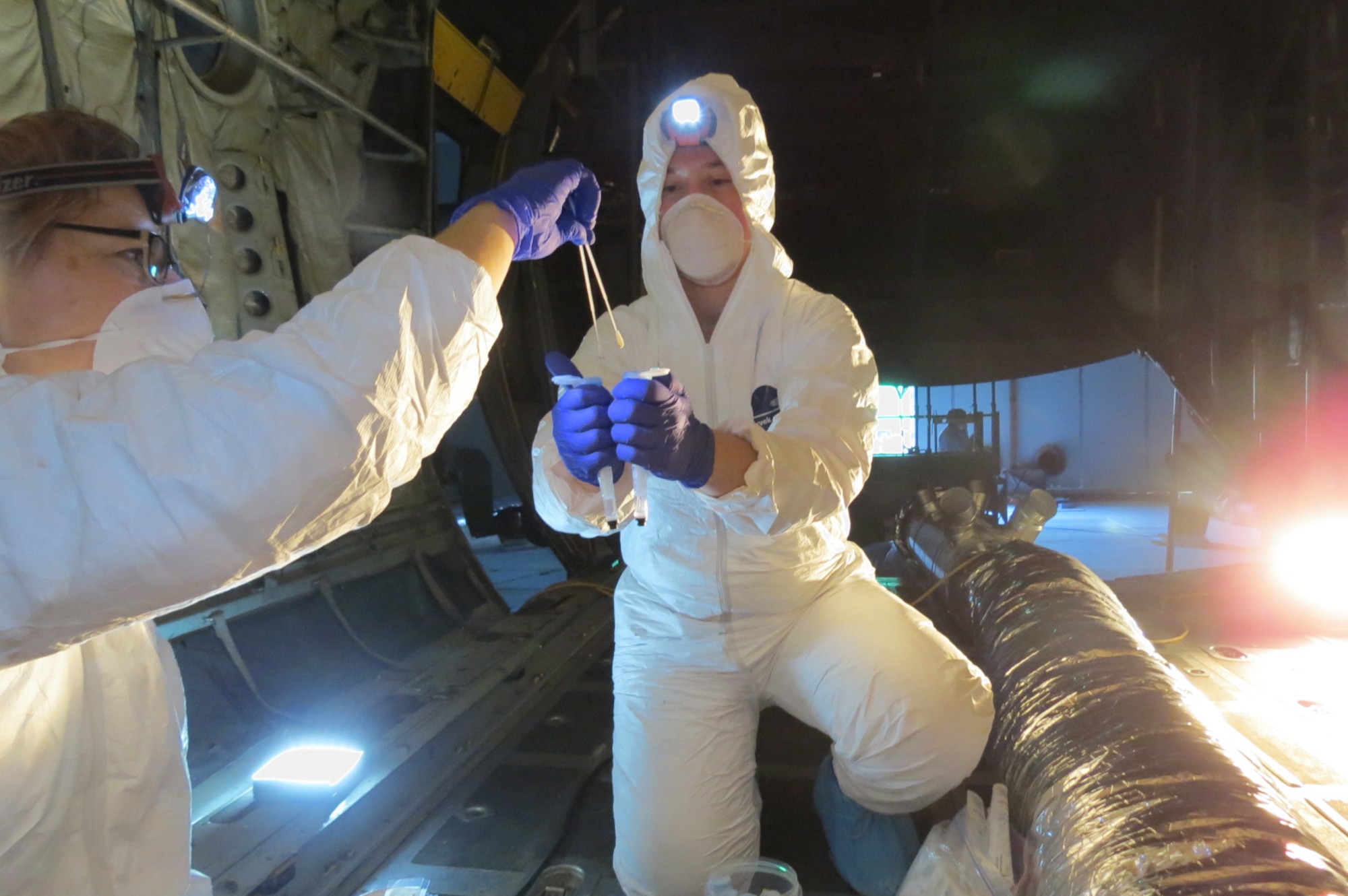 AFRL Biological Materials and Processing Research Team members perform sample tests of various aircraft locations at the conclusion of the Joint Biological Agent Decontamination System process.  (U.S. Air Force photo)