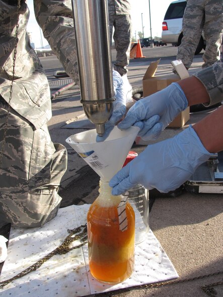 The AFRL Biological Materials and Processing Research Team collects fuel samples from a storage tank to analyze for potential biocontamination.  (U.S. Air Force photo)
