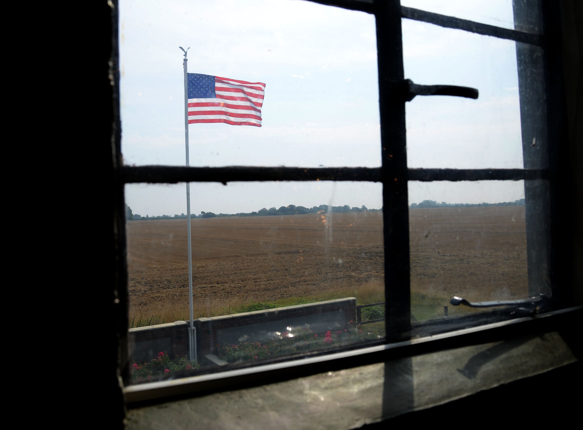 The American Flag flies next to the air traffic control tower Aug. 25, 2016, at the 100th Bomb Group Memorial in Thorpe Abbotts, England. The tower was reconstructed to honor the squadrons and units which served from that airfield between 1943 to 1945. During World War II, the 100th BG suffered tremendous loss during the initial bombing missions, which earned them the nickname, the “Bloody Hundredth.” A group of volunteers, who continue to maintain the museum today, began the preservation of the site in the 1970s. (U.S. Air Force photo by Senior Airman Justine Rho)