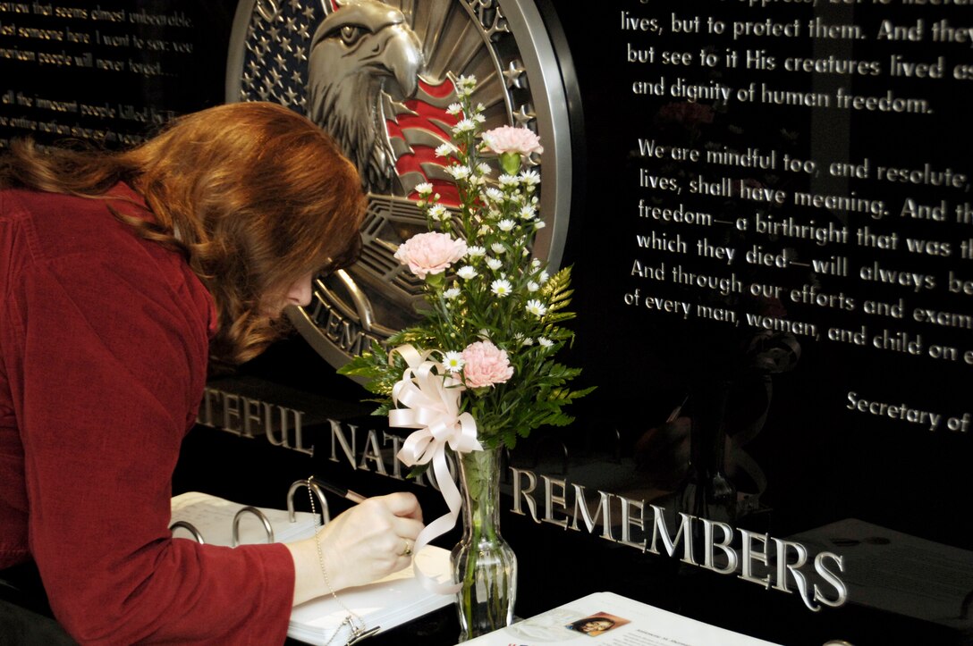 Deb Dunham, the mother of Marine Corps Cpl. Jason L. Dunham, signs the book at the 9/11 Memorial Room during the Pentagon tour at the Pentagon in Washington D.C., Jan. 12, 2007.  The family toured the building before attending the Hall of Heroes ceremony for Dunham, who died April 22, 2004, at Bethesda Naval Hospital in Bethesda, Md., of injuries sustained April 14, when he used his body to shield comrades from a grenade explosion in Husaybah, Iraq.  Marine Corps photo by Sgt. Richard L. McCumber III
