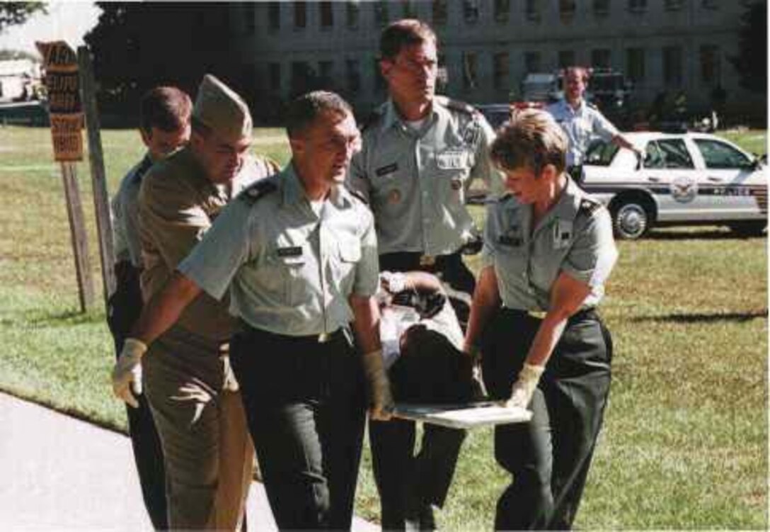 Army and Navy personnel evacuate a person injured in the attack on the Pentagon, Sept. 11, 2001. Navy photo